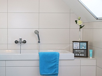 Das Bad im Dachgeschoss mit zwei Waschbecken, Badewanne und Dusche